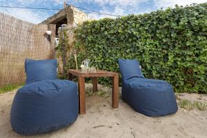 a table with two blue chairs and a wooden table with at Casa Arinto in Palmela