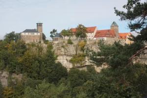 a castle on top of a mountain with trees at Jörgs Ferienwohnung Lohmen in Lohmen