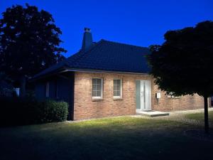 a brick house with a white door in a yard at Ferienhaus Rechlin in Rechlin