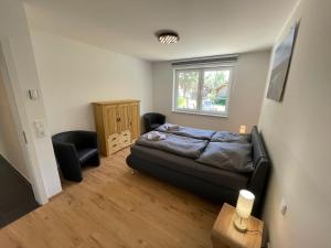 a bedroom with a bed and a chair and a window at Ferienhaus Rechlin in Rechlin