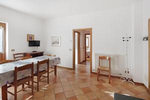 a dining room with a table and chairs and a television at Residence Malibu Appartamento 3 in Falcade