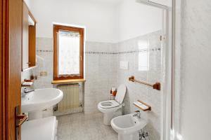 a bathroom with a sink and a toilet and a sink at Residence Malibu Appartamento 3 in Falcade