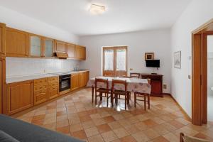 a kitchen with a table and some chairs and a table and a kitchen at Residence Malibu Appartamento 3 in Falcade +19 photos
