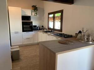 a kitchen with white cabinets and a counter top at Villa Harmony in Quartu SantʼElena