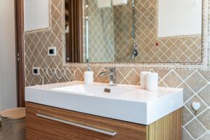 a bathroom with a white sink and a mirror at Villa Harmony in Quartu SantʼElena +27 photos