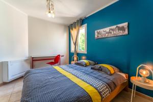 a bedroom with a bed and a blue wall at Villa piscine, clim in Méjannes-le-Clap +20 photos