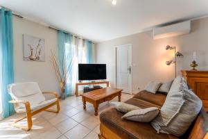 a living room with a couch and a tv at Villa piscine, clim in Méjannes-le-Clap