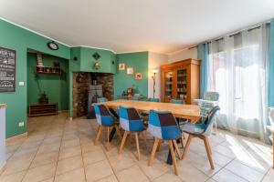 a dining room with a wooden table and blue chairs at Villa piscine, clim in Méjannes-le-Clap