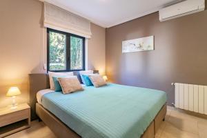 a bedroom with a bed with blue sheets and a window at Villa Mara in El Campello +20 photos