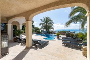 a patio with lounge chairs and a swimming pool at Villa Mara in El Campello