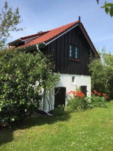 a small house with a black and white roof at Villa Ilsebill in Ribnitz-Damgarten