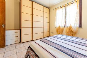 a bedroom with a bed and a dresser at Magy House in Quartu SantʼElena