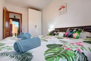 a bedroom with a large bed with blue pillows at Villa Dayely in Corralejo +19 photos