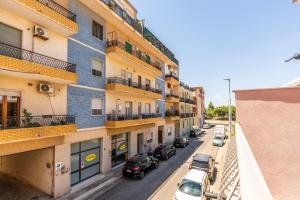 an apartment building with cars parked on a street at Magy House in Quartu SantʼElena