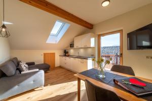 a kitchen and a living room with a couch and a table at Weinangerhof St Pauls in Missiano