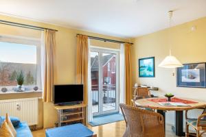 a living room with a tv and a table with a tableablish at Ferienwohnung Tannenblick 1-2 in Oberhof