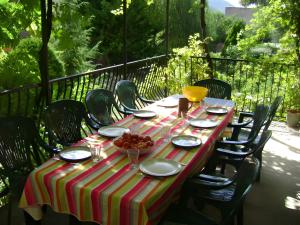 a table with plates and bowls of fruit on it at Maison L'oustal Du Lévéjac in Saint-Rome-de-Tarn