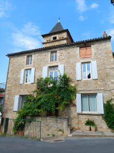 a stone building with a tower on top of it at Maison L'oustal Du Lévéjac in Saint-Rome-de-Tarn