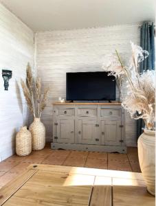 a living room with a television on a cabinet at Ferienhof Reimers in Wesselburenerkoog