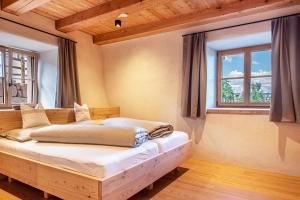 a bedroom with a bed and two windows at Egger an der Lahn - Apt Nonno in San Genesio Atesino