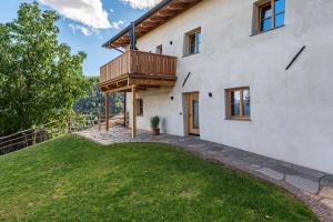 a house with a deck on the side of it at Egger an der Lahn - Apt Nonno in San Genesio Atesino