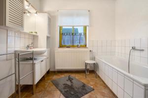 a white bathroom with a tub and a sink at Ferienhaus Poggenkrug Halbsguth in Wolgast +24 photos