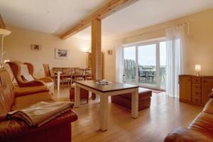 a living room with a table and a dining room at Ferienhaus Poggenkrug Halbsguth in Wolgast