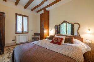a bedroom with a large bed with a wooden headboard at Casa Argentera Full House in Argentera