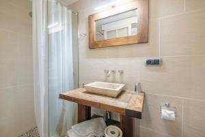a bathroom with a sink and a mirror on the wall at Casa Argentera Full House in Argentera +26 photos