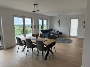 a dining room and living room with a table and chairs at Berg und Meer in WÃ¶lpinghausen