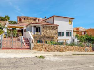 a house with a stone wall and a fence at Villa Poldina in Budoni