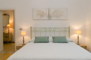 a bedroom with a white bed with two green pillows at Brezza Marina Apartment in San Vincenzo