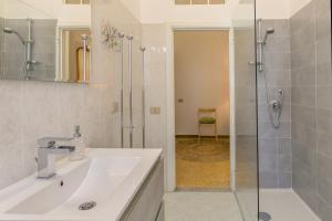 a bathroom with a sink and a glass shower at Brezza Marina Apartment in San Vincenzo