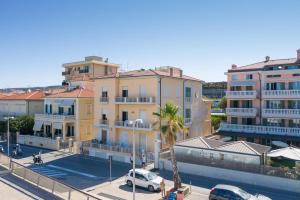 a group of buildings with cars parked in a parking lot at Brezza Marina Apartment in San Vincenzo