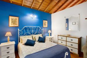 a blue bedroom with a bed and a blue wall at La Roquina in Tijarafe