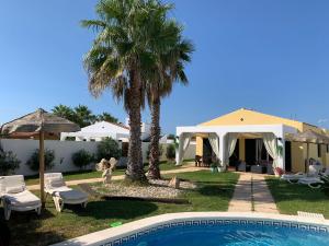 a resort with a swimming pool and palm trees at Chalet con piscina en Menorca in Cala en Bosc