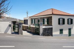 a house with a gate on the side of a street at Mother's House in Calheta