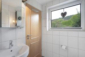 a bathroom with a sink and a window at Auszeit Sauerland in Olsberg +40 photos
