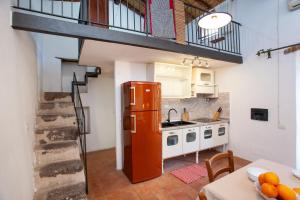 a kitchen with a refrigerator and a table in a room at Hora Hora in Orosei +12 photos