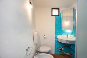 a bathroom with a toilet and a sink at Hora Hora in Orosei