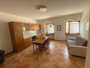 a kitchen and living room with a table and a couch at Residence Malibu Appartamento 2 in Falcade +16 photos