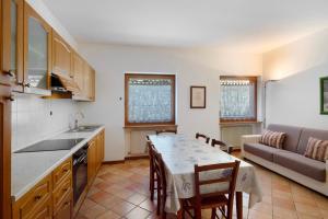 a kitchen and living room with a table and a couch at Residence Malibu Appartamento 2 in Falcade