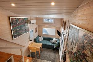 a tiny house with a couch and a table at Tiny House Nr 1 in Schwielowsee