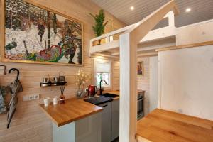 a kitchen with wooden walls and a staircase in a tiny house at Tiny House Nr 1 in Schwielowsee