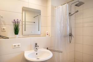 a white bathroom with a sink and a shower at Ferienwohnung in Mecklenburg in Malchin +33 photos