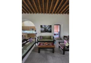a living room with a couch and a table at Villa Two Pine Trees in Alinda