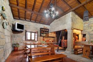 a dining room with wooden tables and a stone fireplace at Casa do Adro do Soajo in Soajo