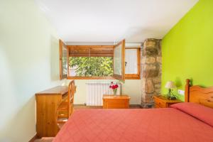 a bedroom with a red bed and a green wall at Casa Ramona in Conques