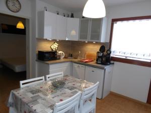 a kitchen with a table with chairs and a counter top at studio la joue du loup in Le Dévoluy