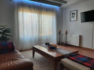 a living room with a coffee table in front of a window at Cortijo Ramonsillos in Villanueva del Trabuco
